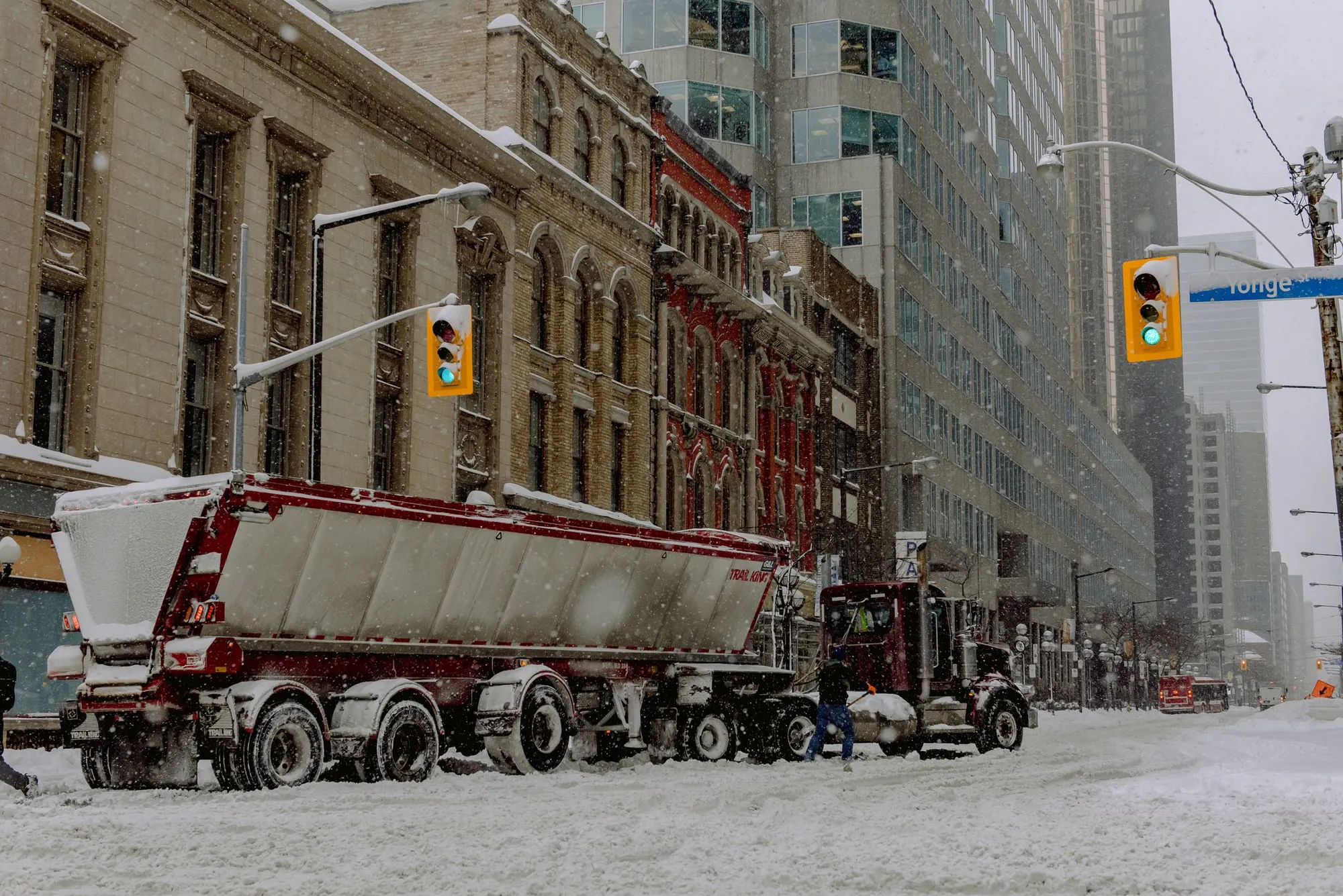 Commercial trucks operating on a snow-covered city street